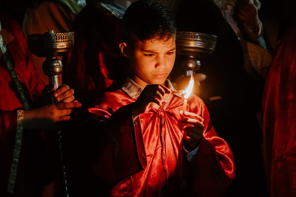 Niño sosteniendo una vela encendida