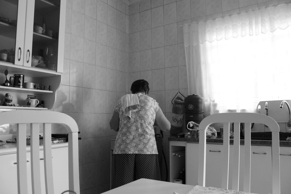 grayscale photography of woman in kitchen
