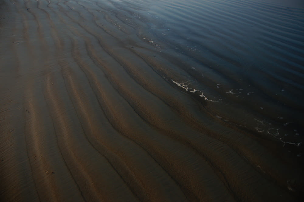 a sandy beach with ripples in the sand