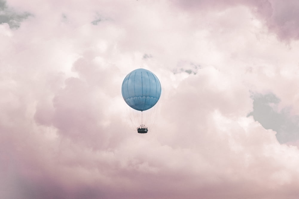 Blauer Heißluftballon auf Wolken
