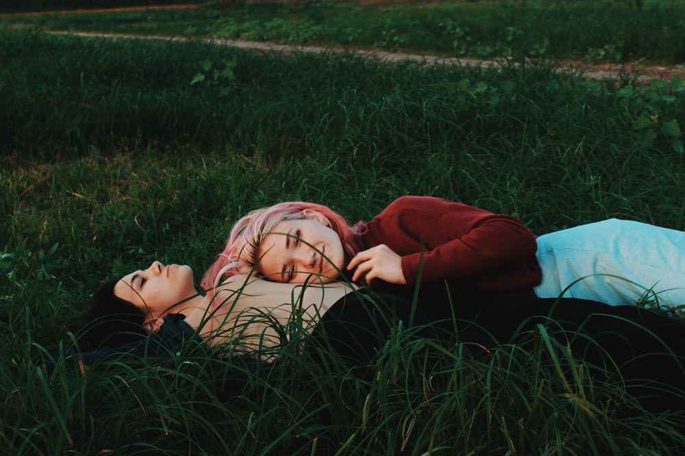 緑の芝生に横たわる二人の女性