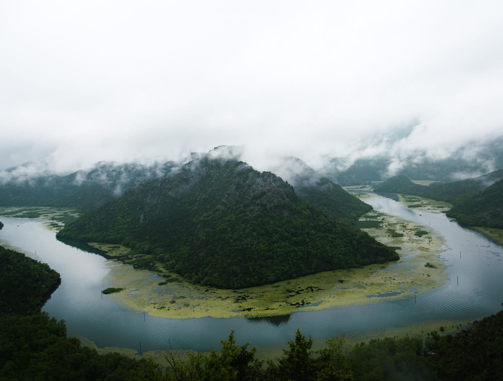 aerial photo of river and mountain during cloudy day