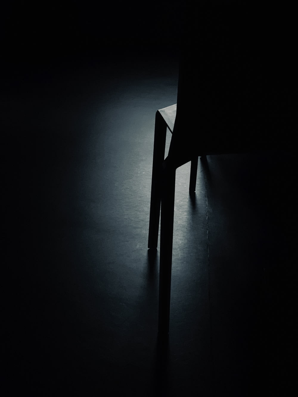 a black and white photo of a chair in the dark