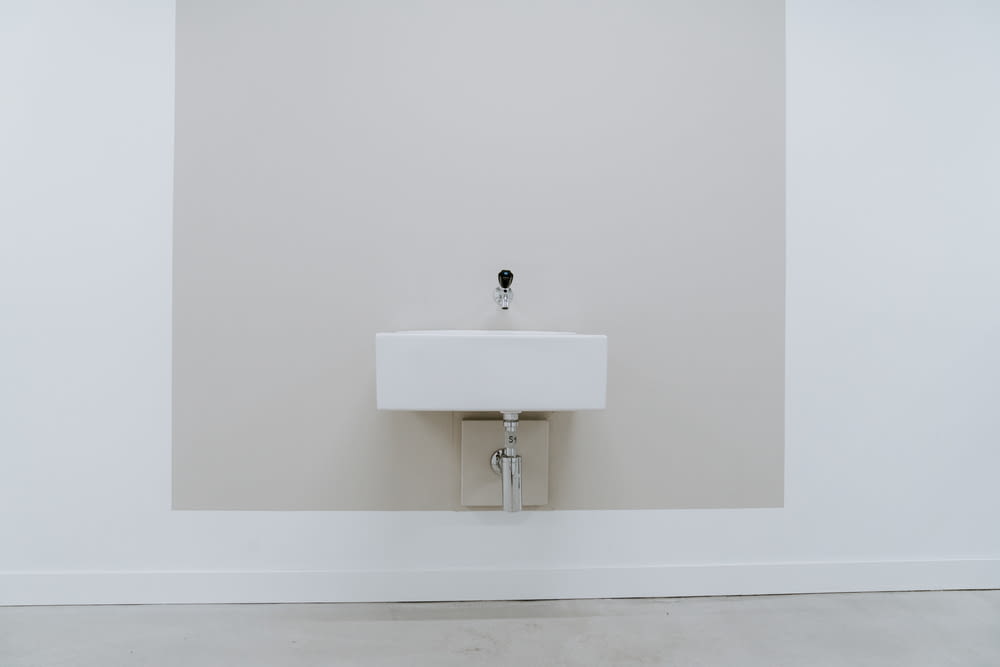 square white ceramic sink near wall