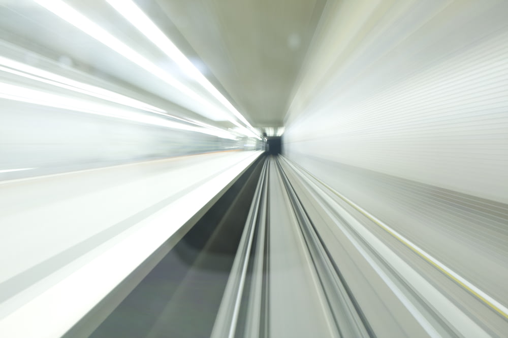 uma foto desfocada de um trem passando por um túnel