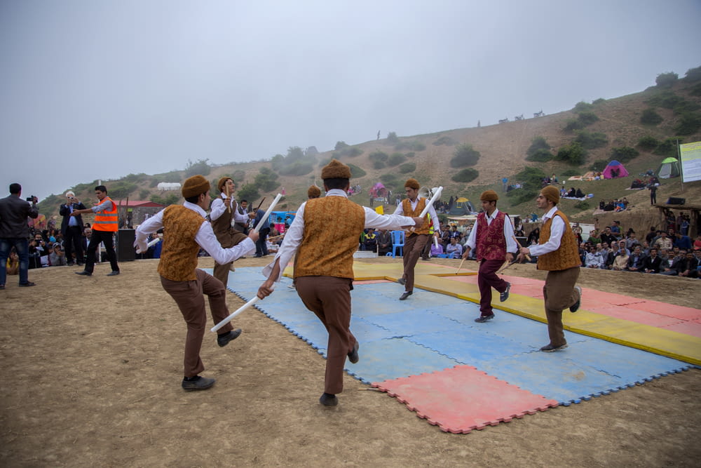 men dancing on puzzle floor mats outside near people during day