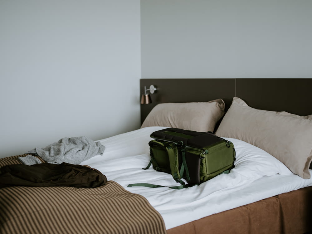 green backpack on bed