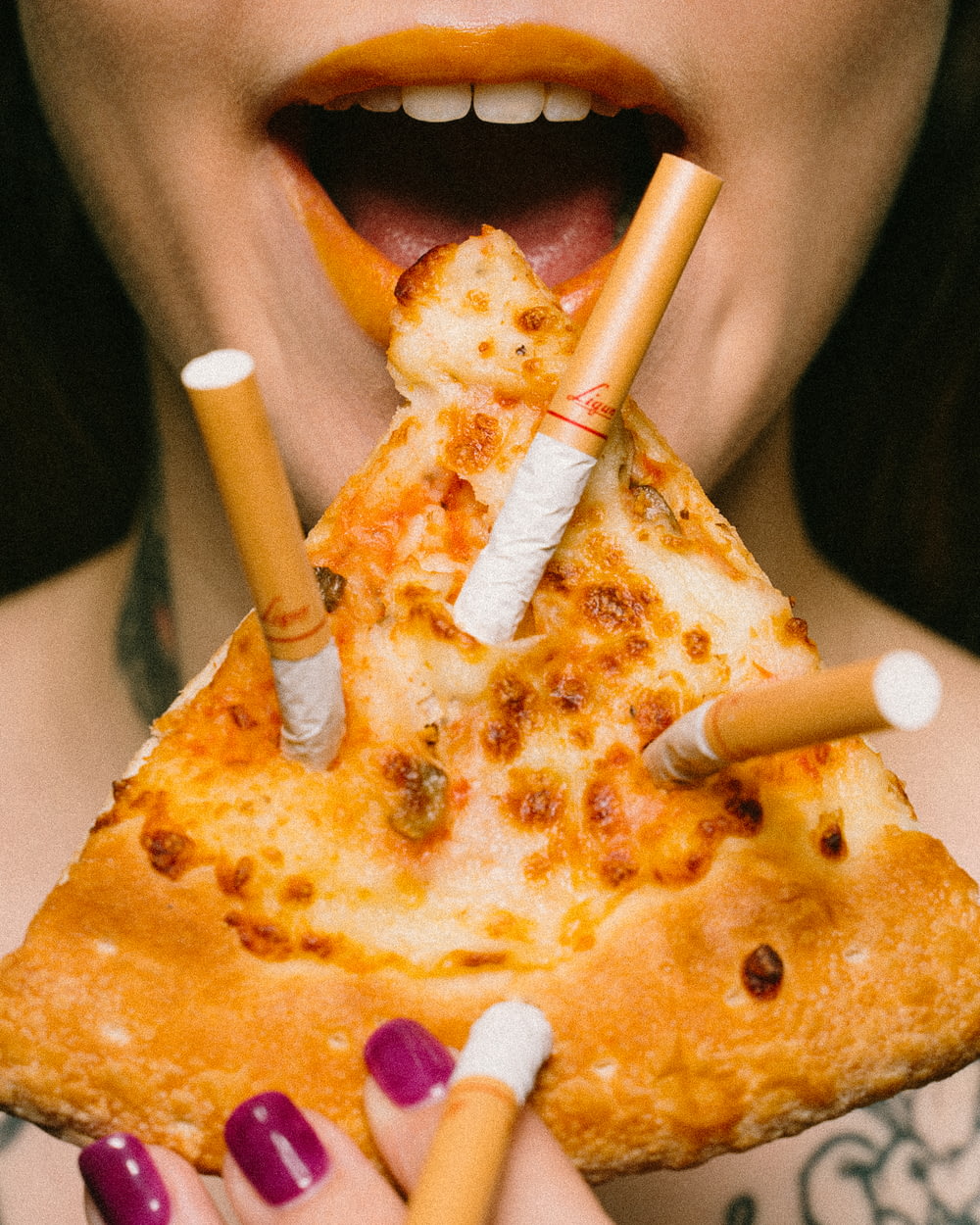 slice of pizza with three cigarette sticks