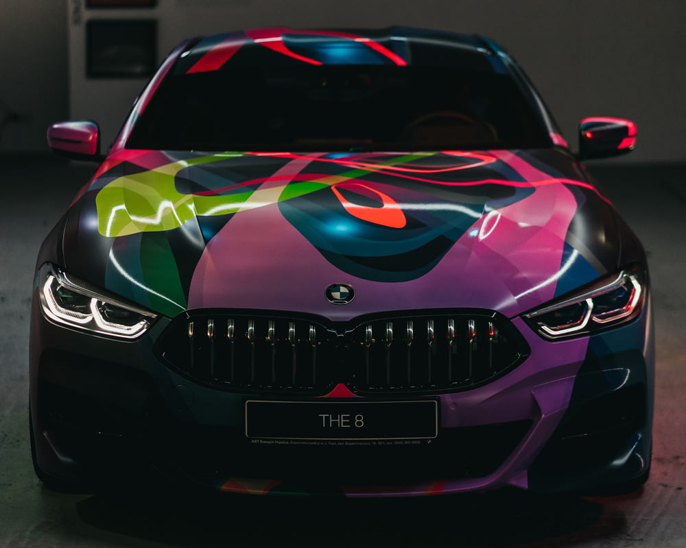 black and multicolored BMW car parked on gray floor