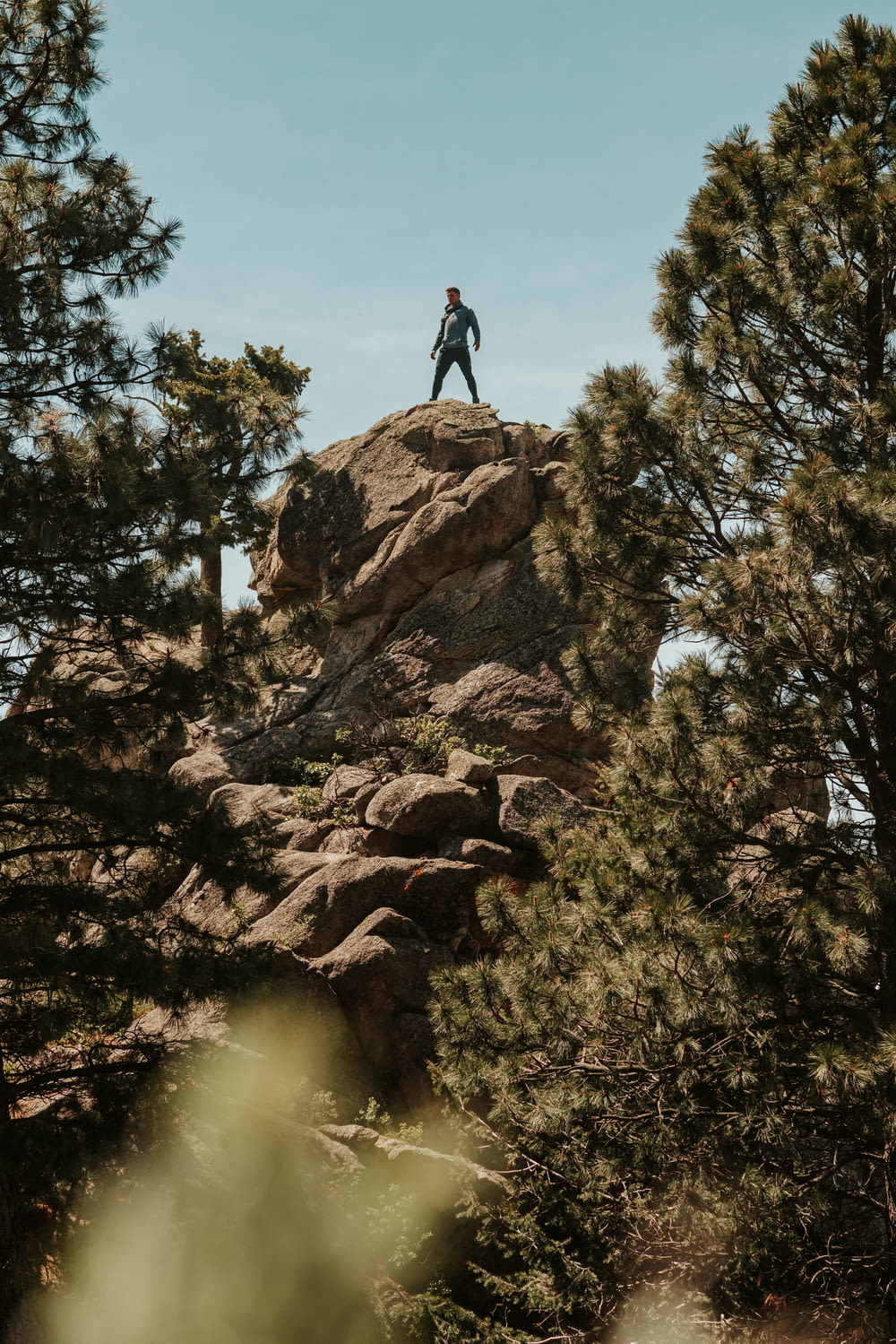 person standing on rock under blue sky