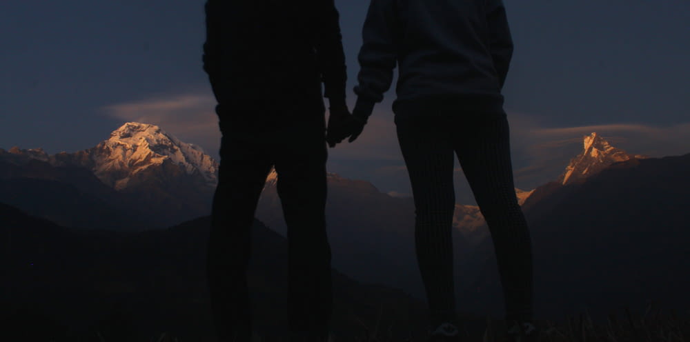 silhouette photo of two people holding hands