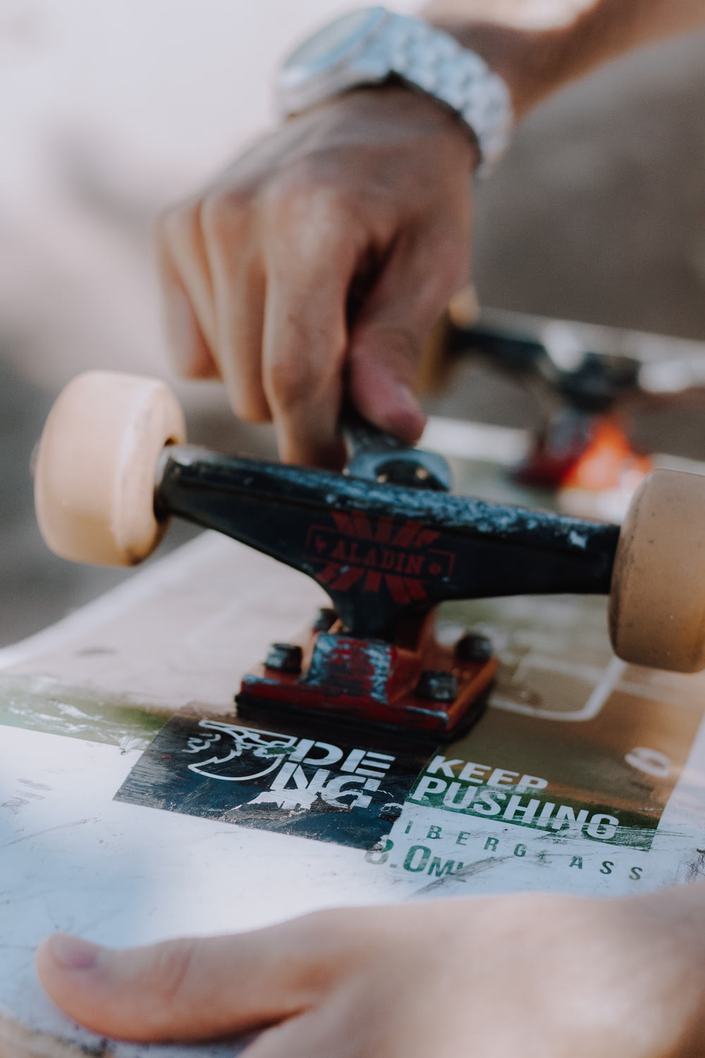 close-up photo of person repairing skateboard