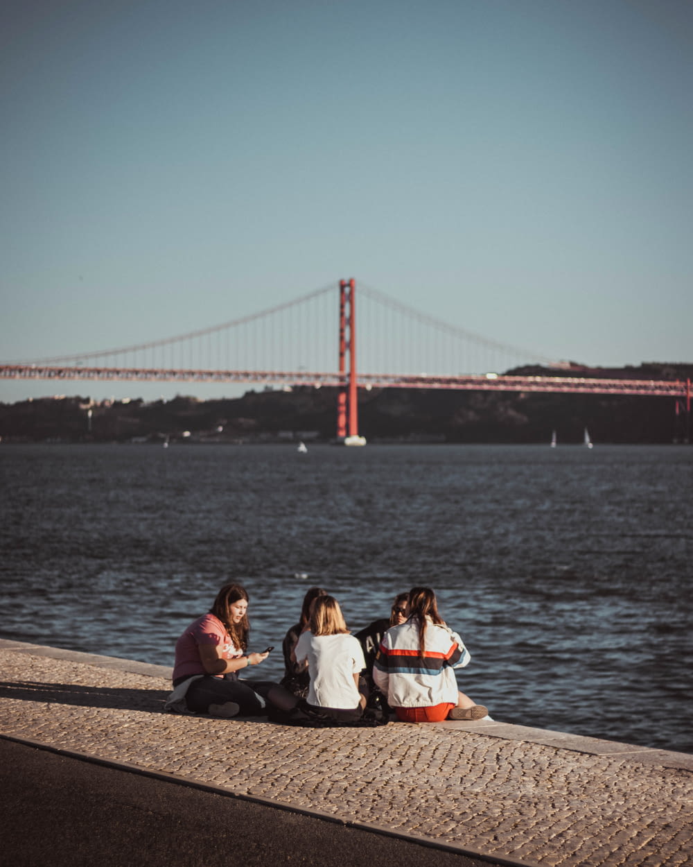 women sitting near Golden Gate bridge