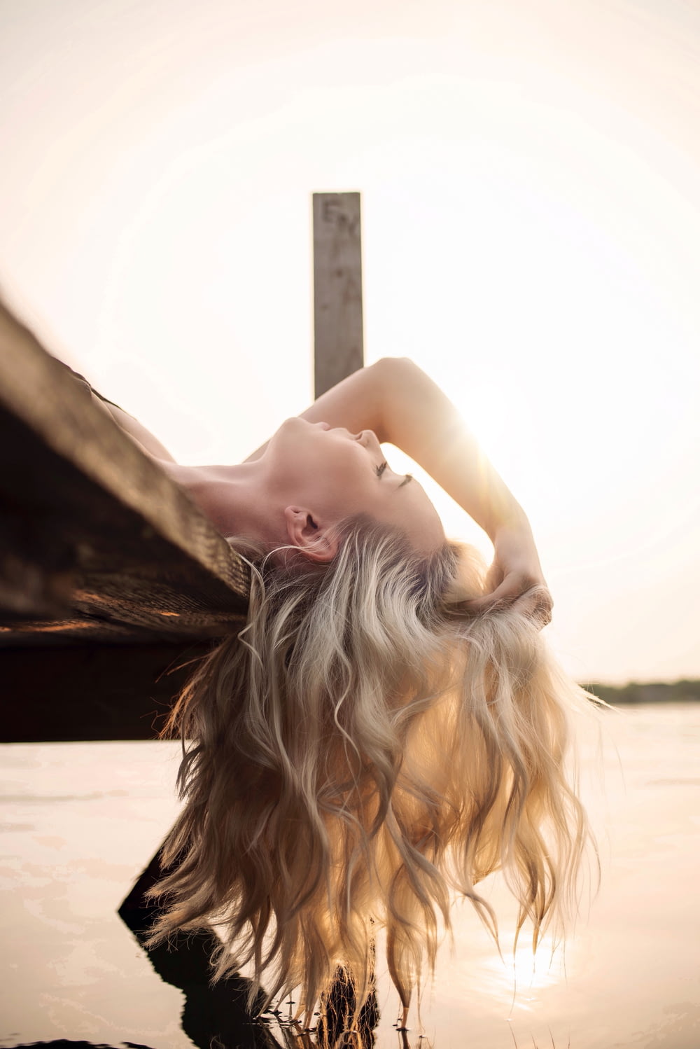 woman lying on river dock