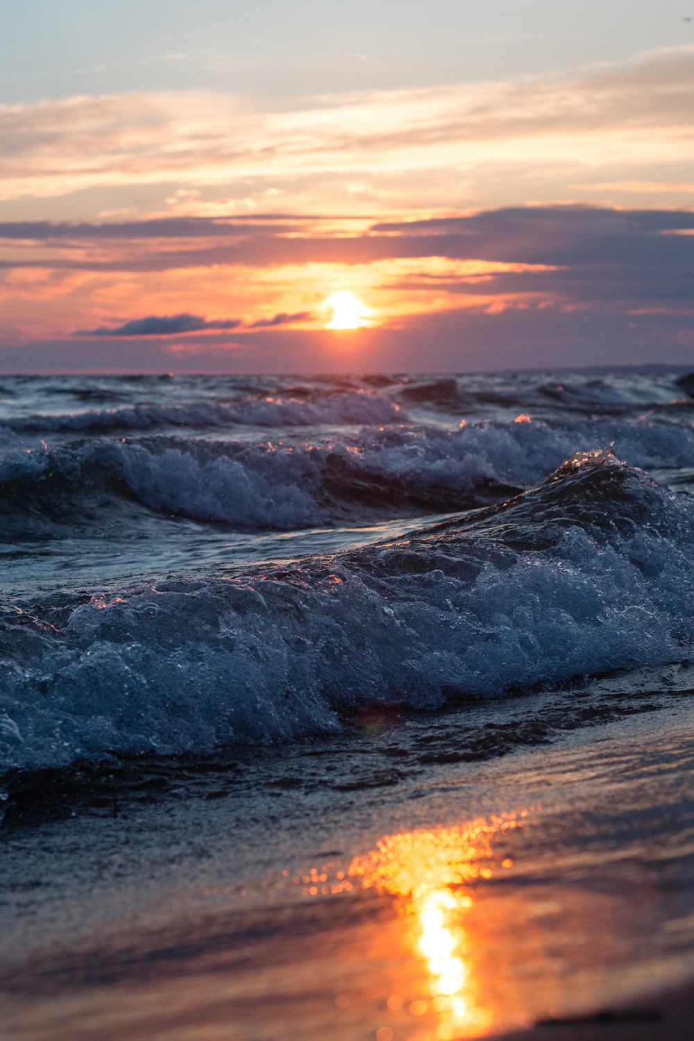 landscape photo of a sea waves on a beach at sunset