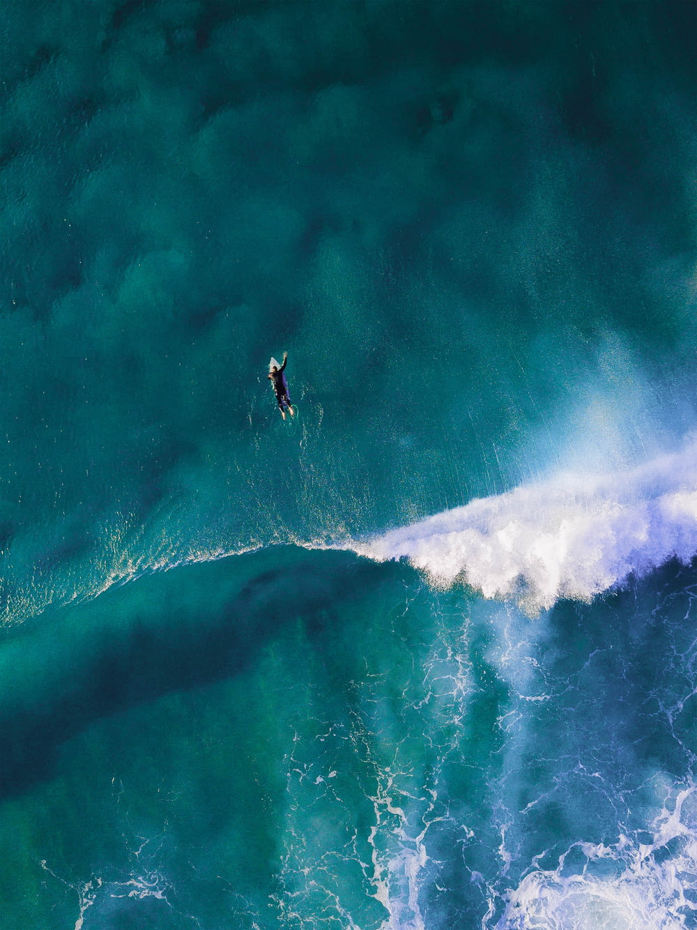 거대한 파도를 서핑하는 남자의 하이 앵글 사진