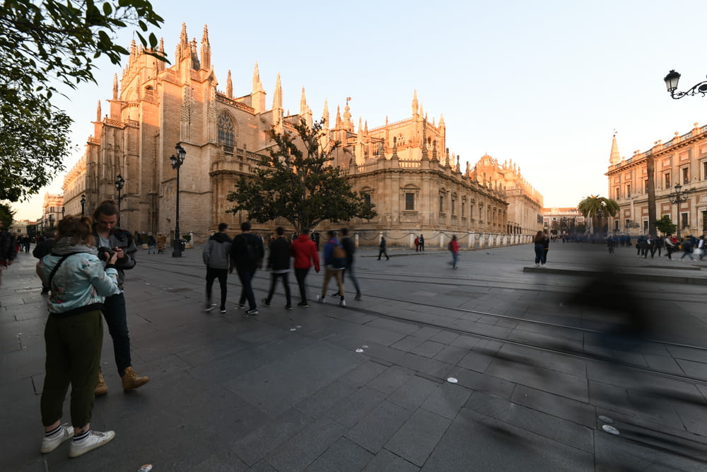 people walking near brown concrete church during daytime