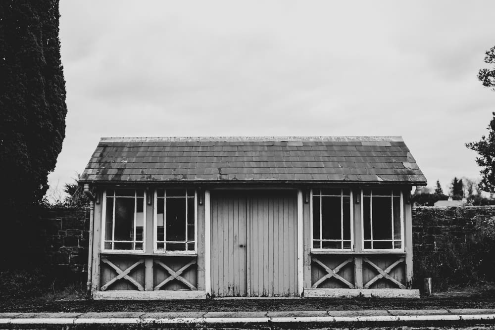 grayscale photo of wooden shed