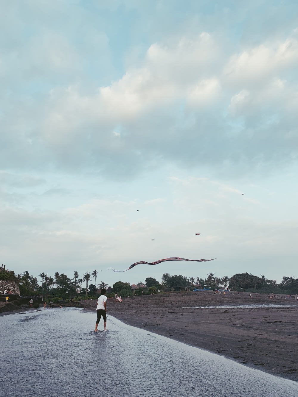landscape photo of a man flying a kite