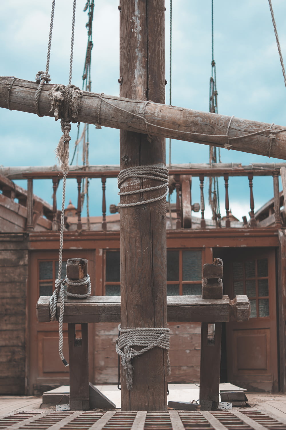 a wooden structure with ropes and a building in the background