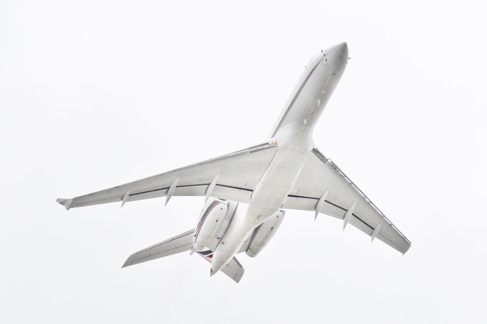white passenger plane passing overhead