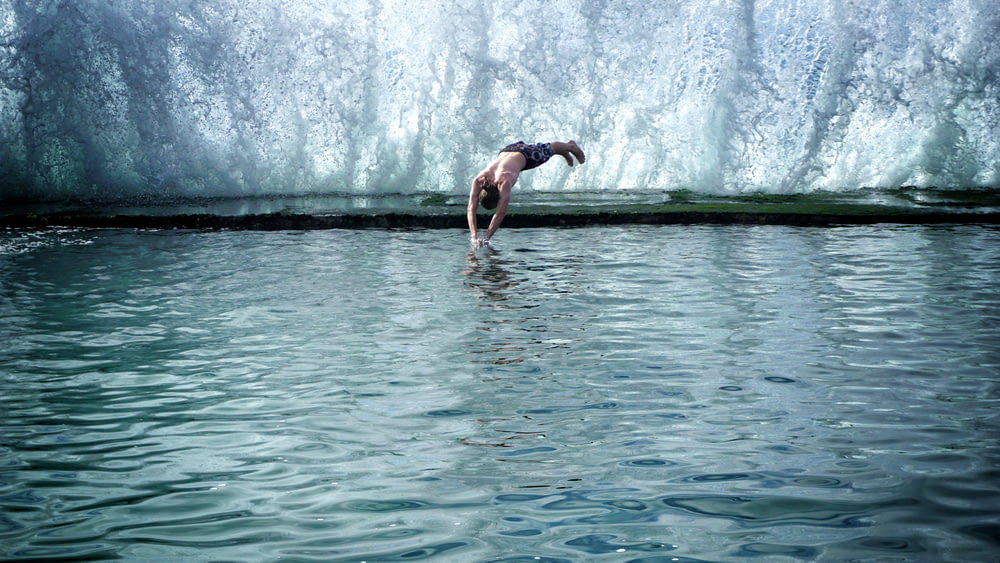 man jumping into pool