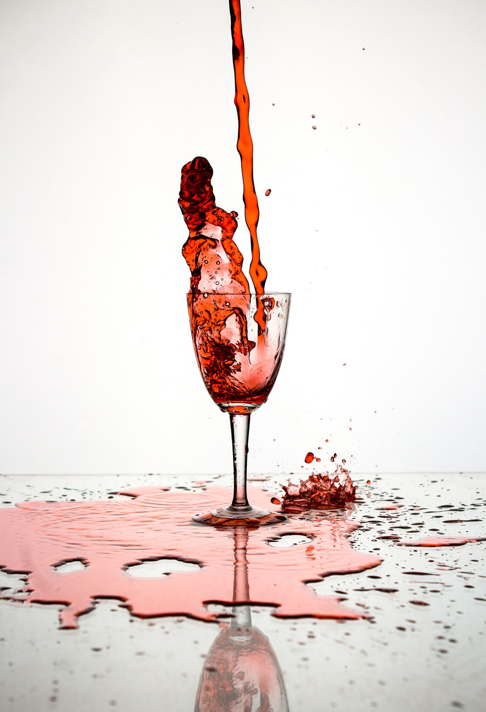 red liquid poured on wine glass