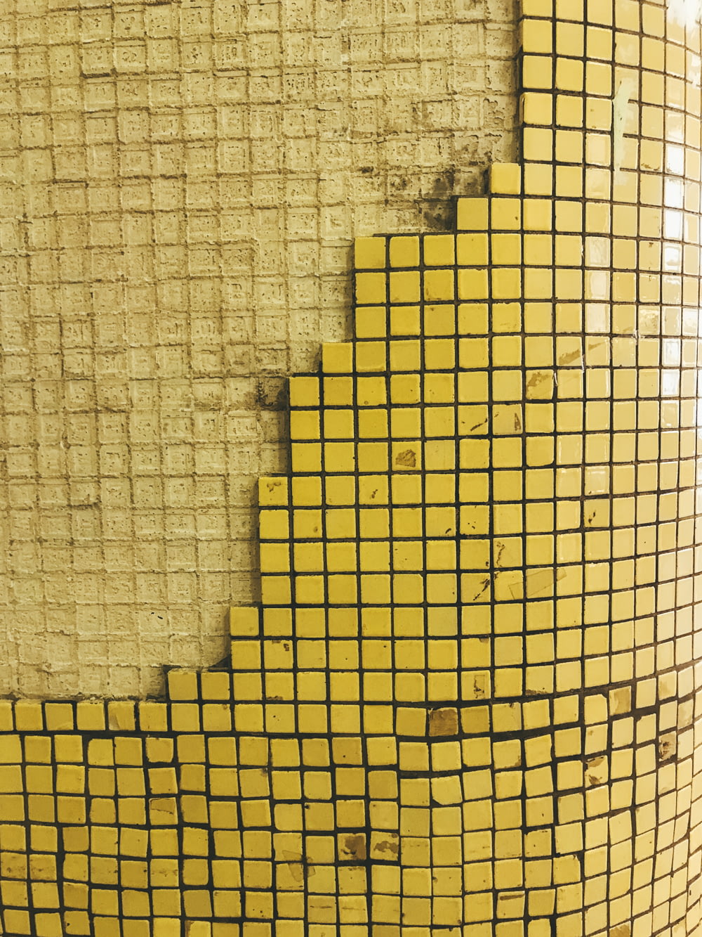 a close up of a yellow and black tiled wall