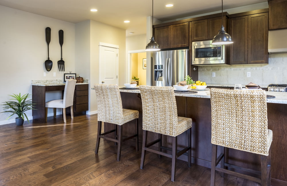 three brown wooden chairs in front of kitchen counter