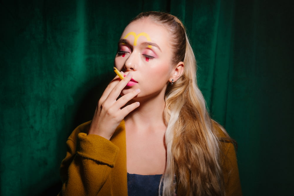 woman in yellow cardigan smoking a cigarette
