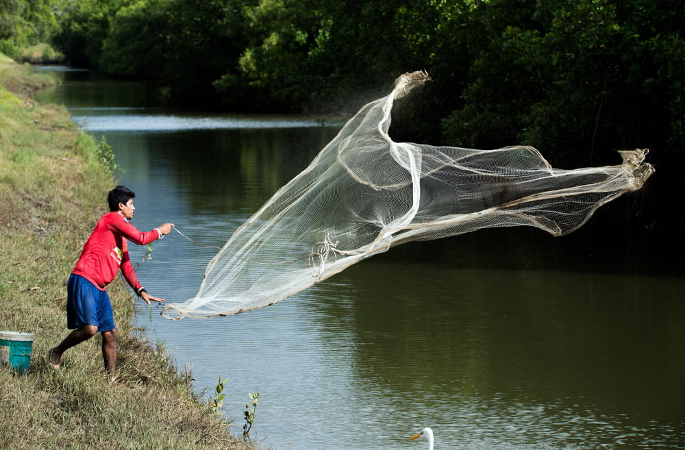 homem jogando rede de peixe branco