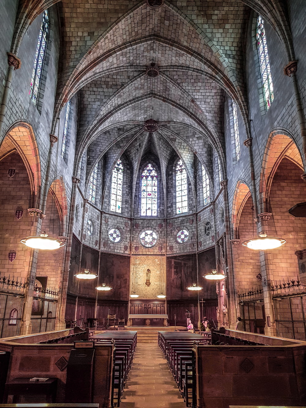o interior de uma igreja com bancos e vitrais