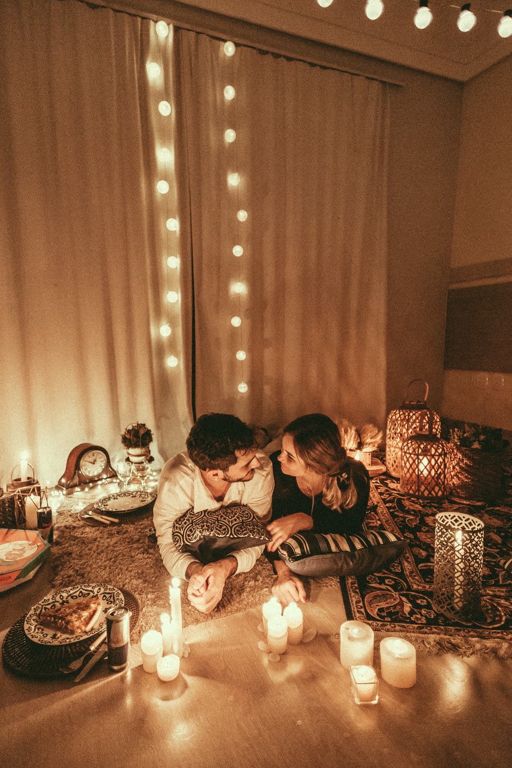 couple lying in carpet with candlelight