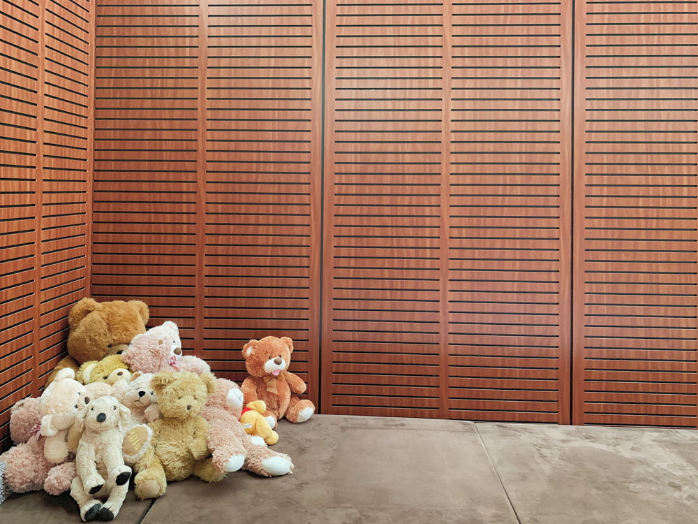 pile bear plush toys beside wall