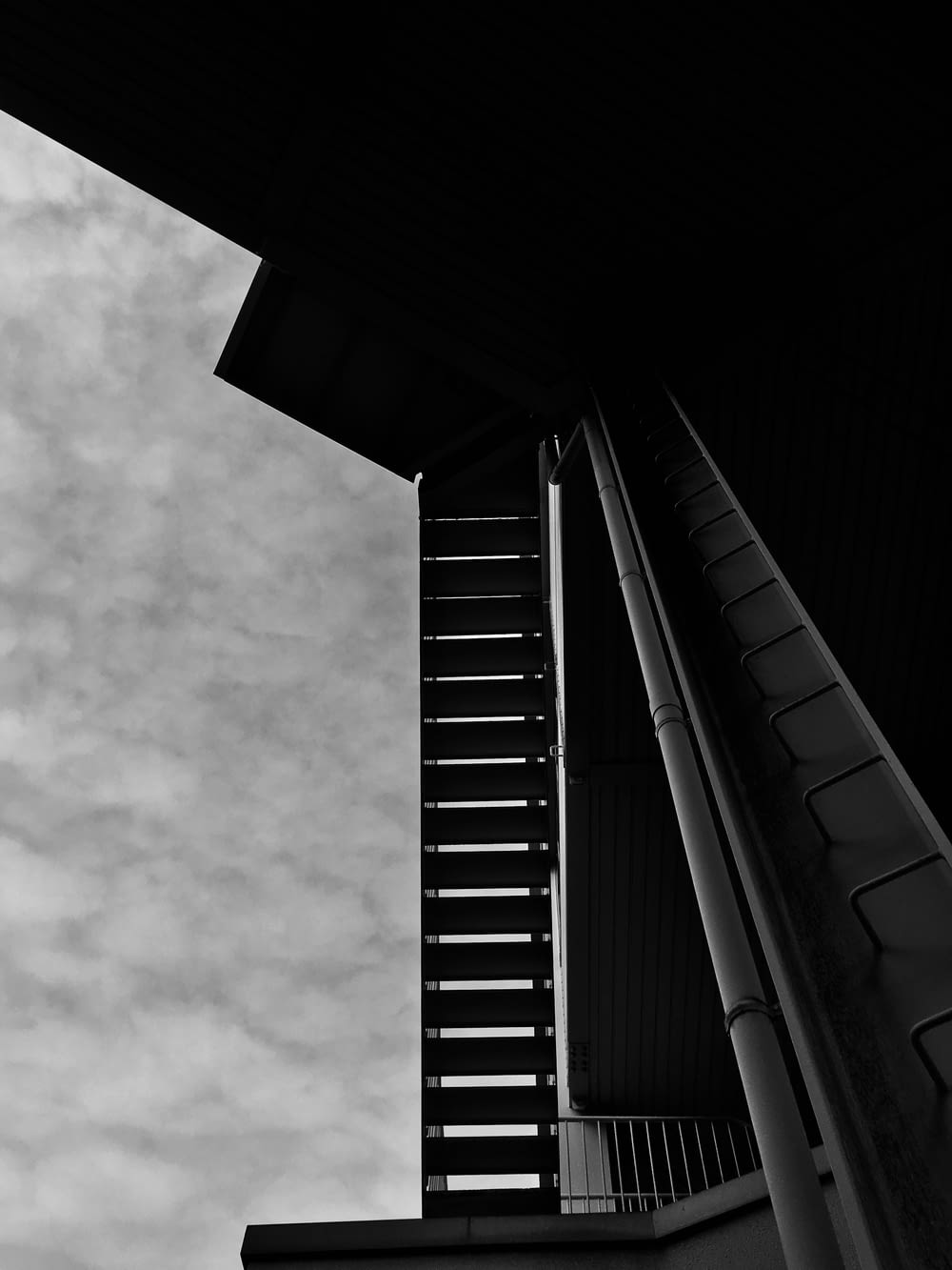 Photo en niveaux de gris d’un bâtiment sous un ciel nuageux