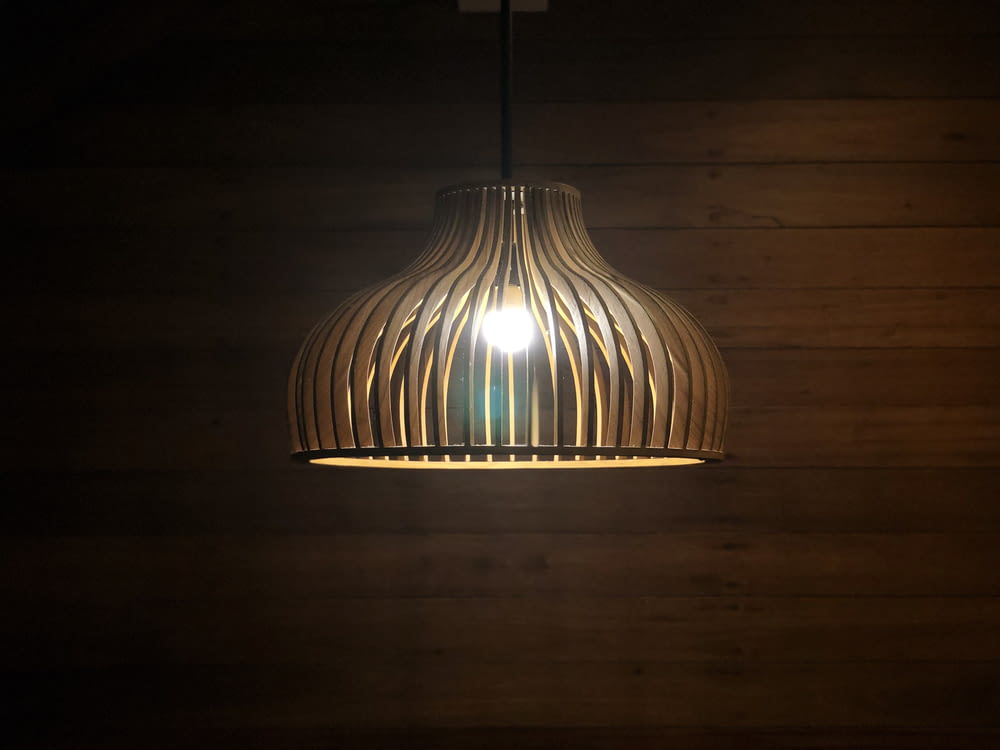 turned-on round brown pendant lamp