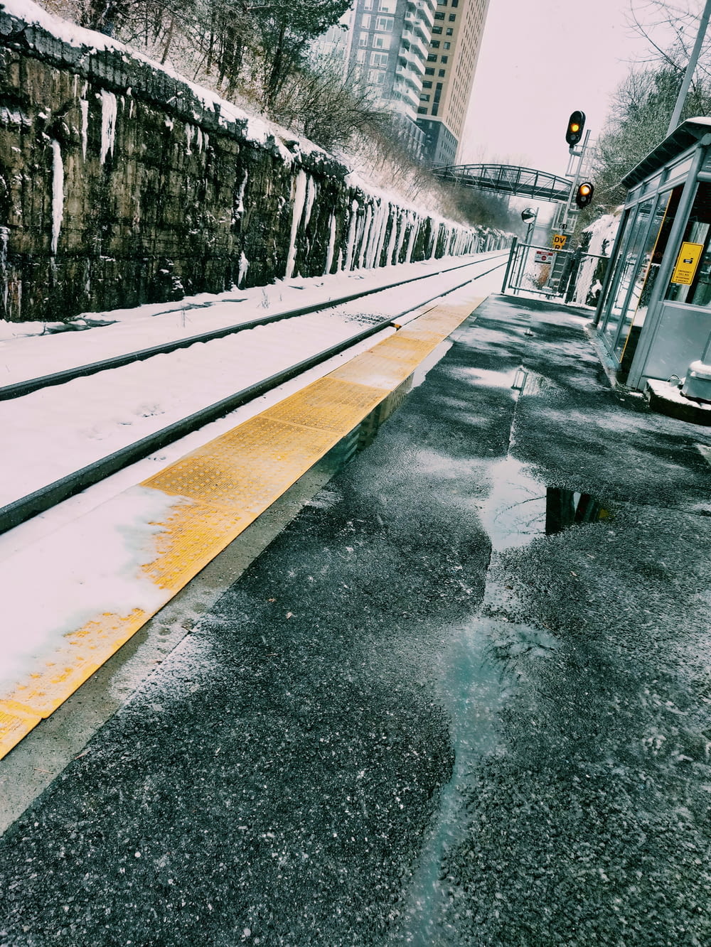 a train is stopped at a train station in the snow