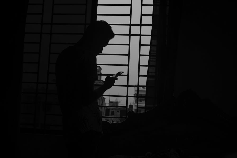 silhouette of man using mobile phone