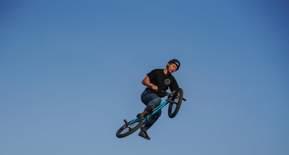 man riding BMX bike under blue sky