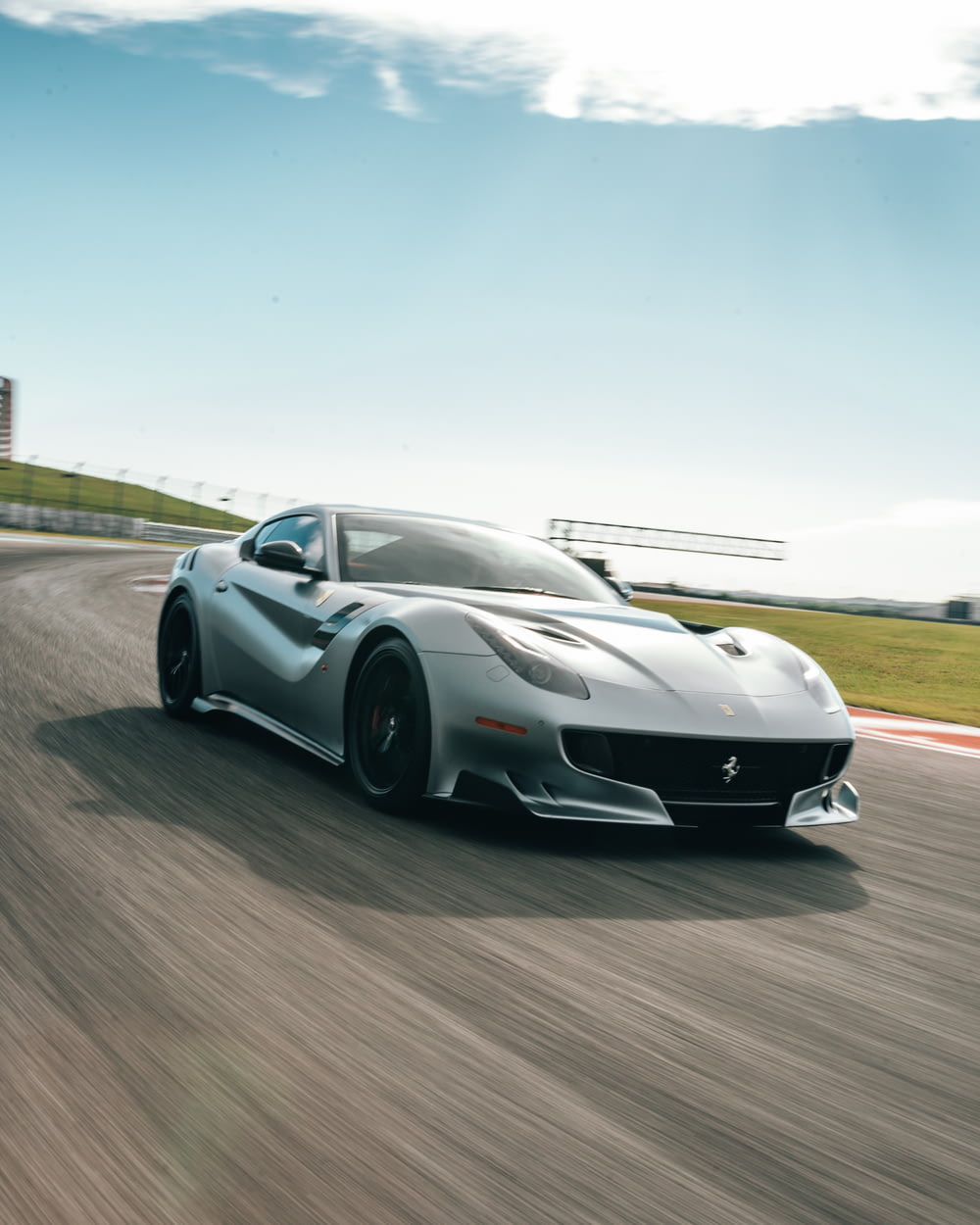 silver Ferrari coupe passing on road during daytime screenshot