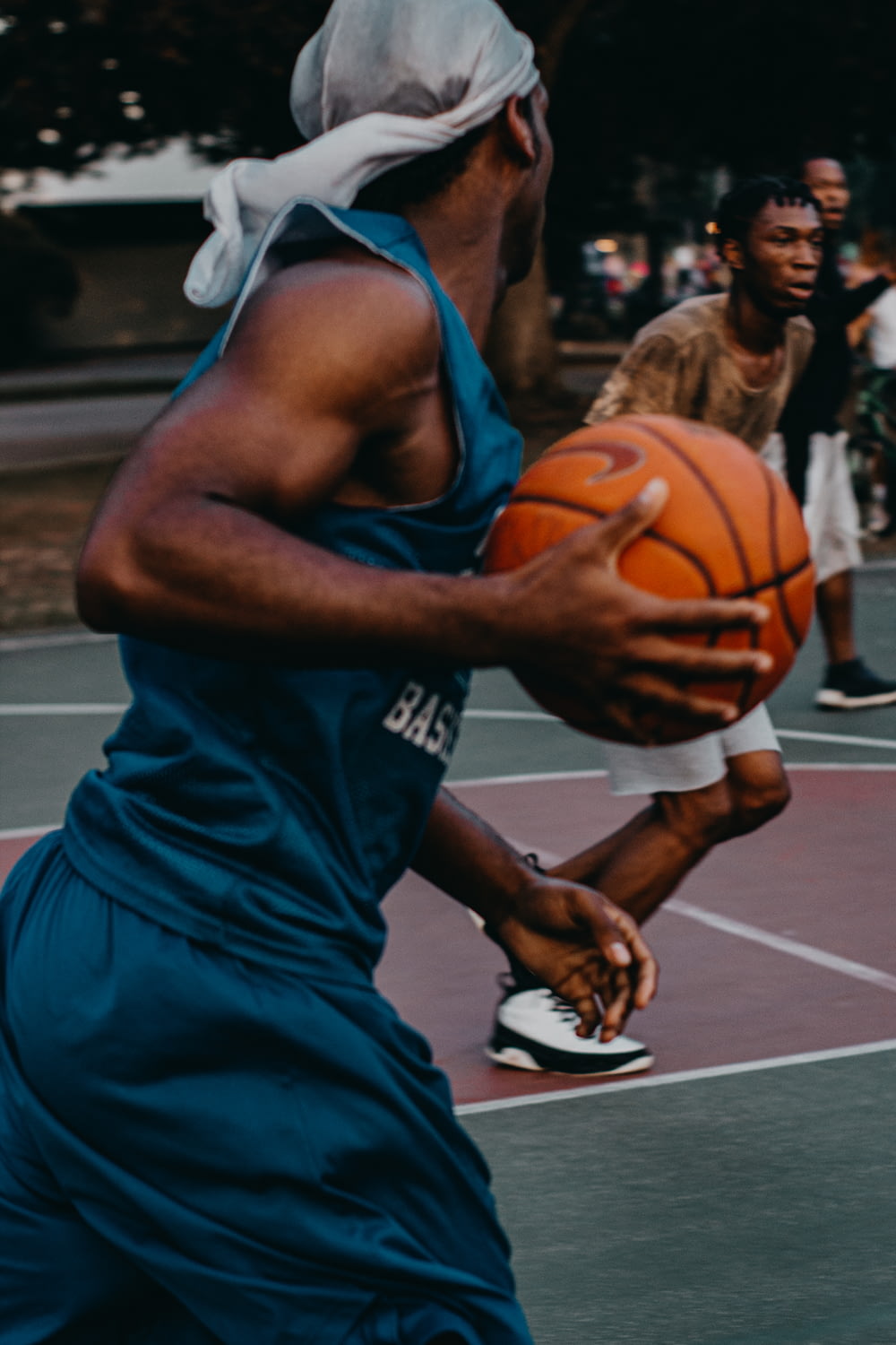 man in blue basketball uniform with ball in court