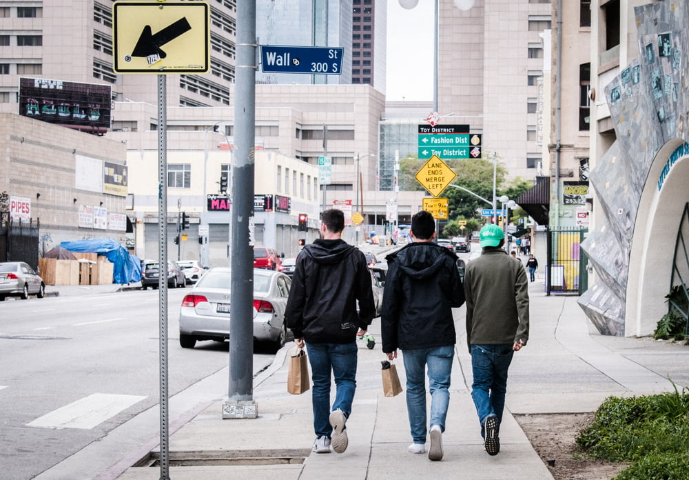 trois hommes marchant dans la rue pendant la journée