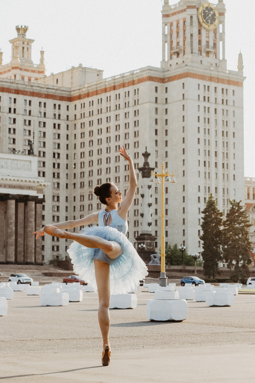 ballerine dansant près d’un bâtiment en béton blanc pendant la journée