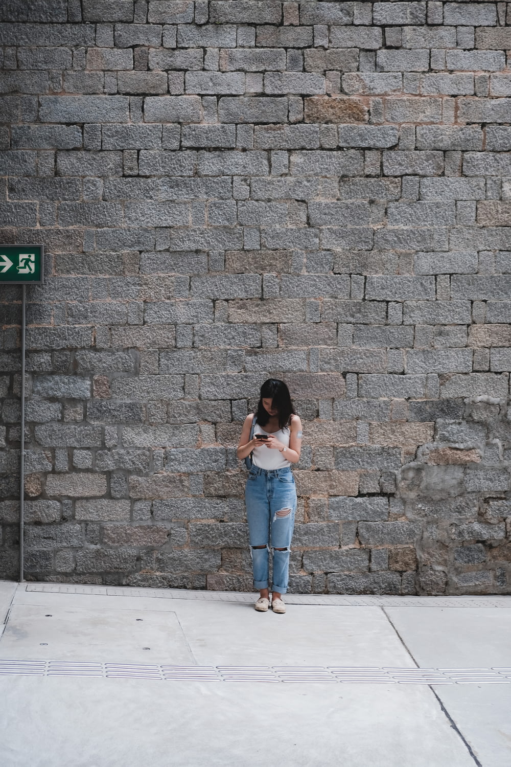 Mujer de pie frente a una pared gris