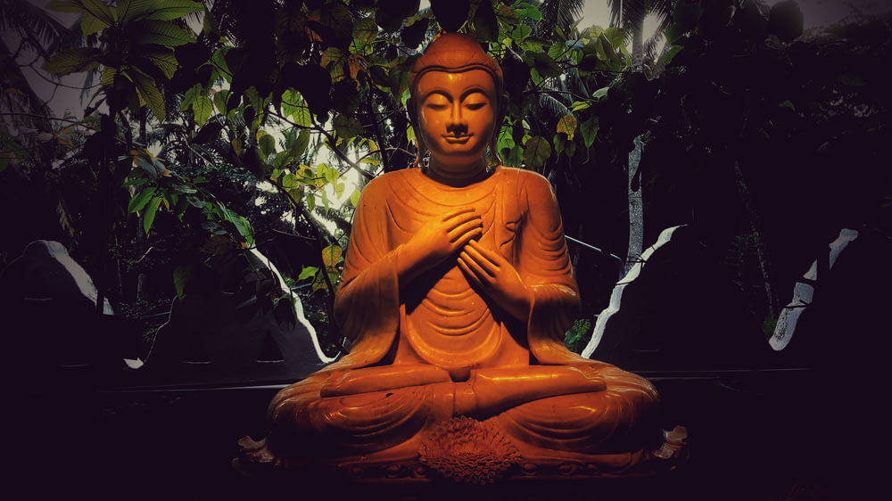 Gautama Buddha figurine near plants