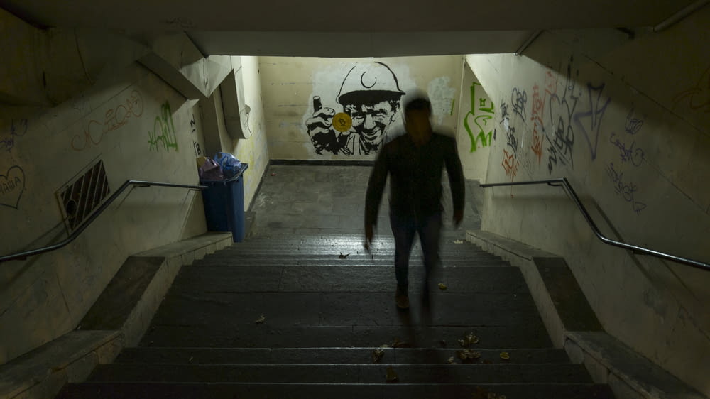 person standing on tunnel surrounded by concrete wall