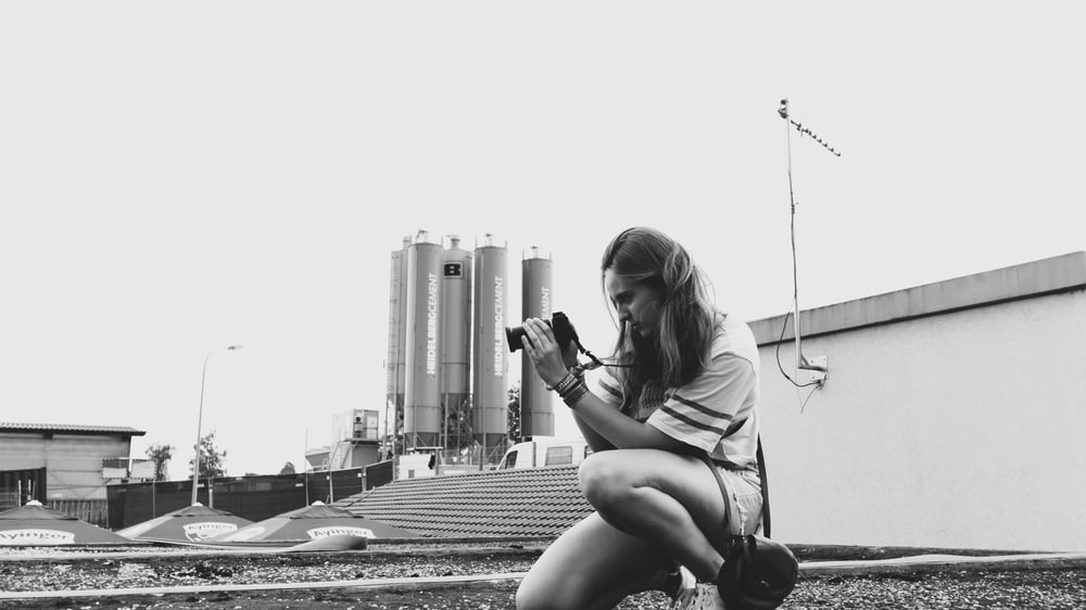 grayscale photography of woman taking photo