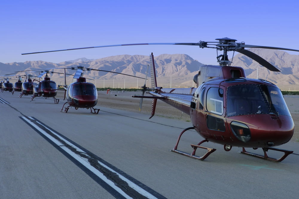 photography of red helicopters on road during daytime