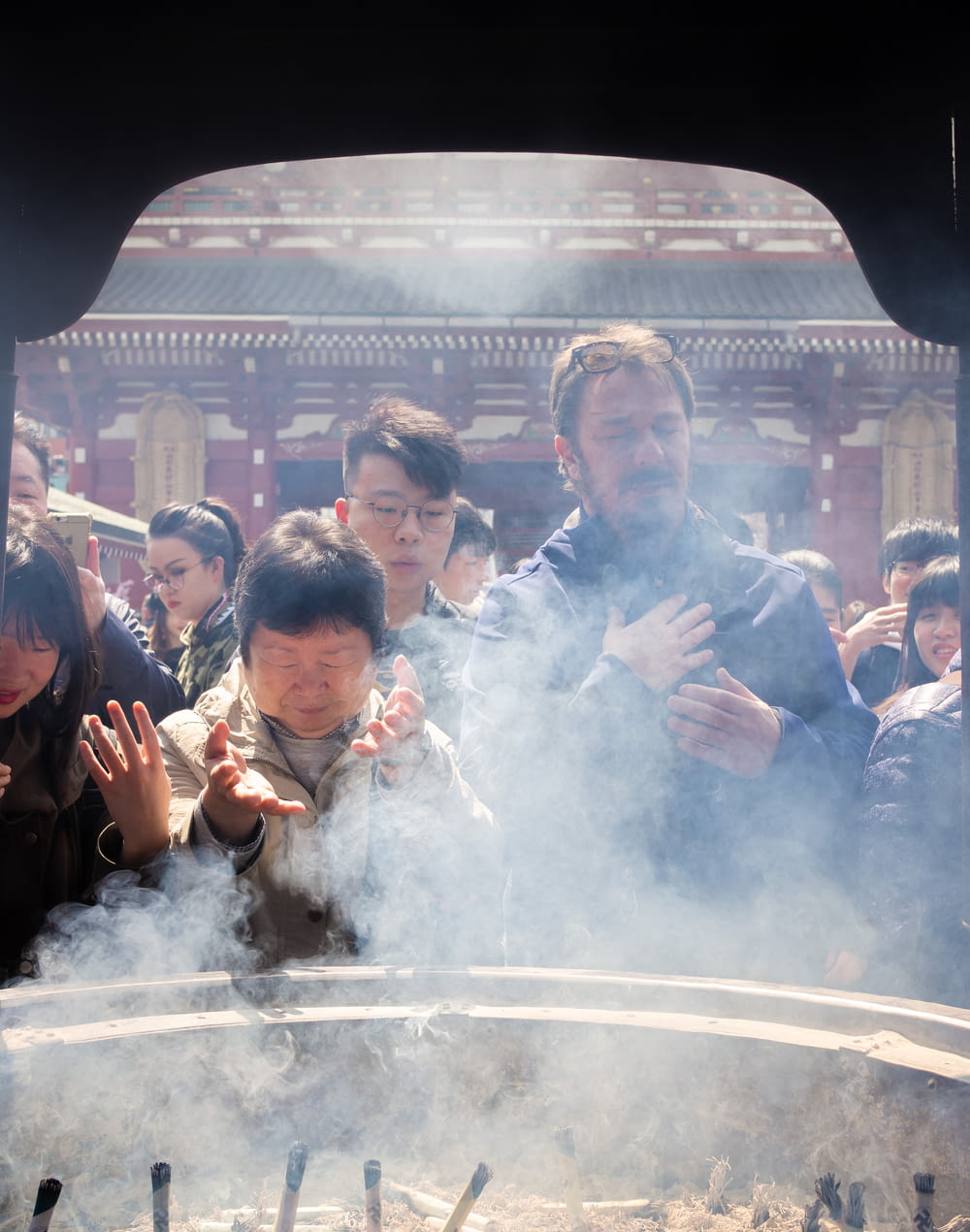 people standing near altar with incenses