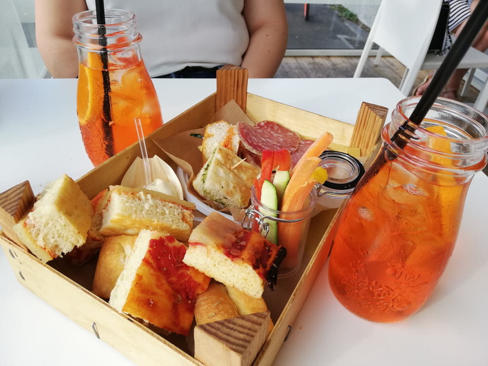 box of comfort food on table with glass of juices